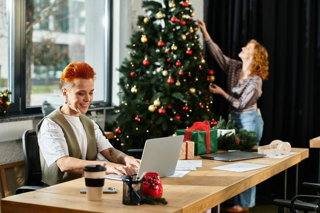 Young professionals engage in cheerful holiday decorating while enjoying their office workspace