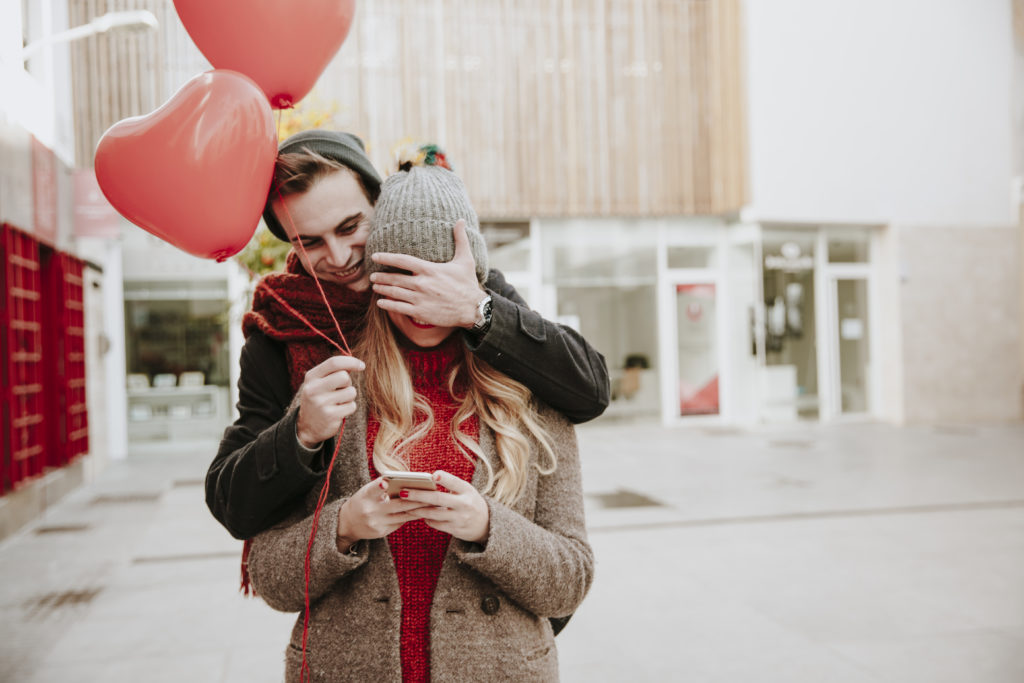 couple on a outing for valentines day with red heart balloons 